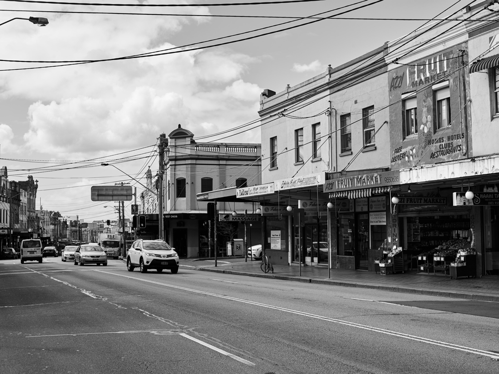 Enmore Road stretches across the frame, with the facade of Azzi's fruit shop visible to the right