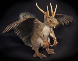A mammalian creature with antlers, fangs, feathers, hooves and scales.